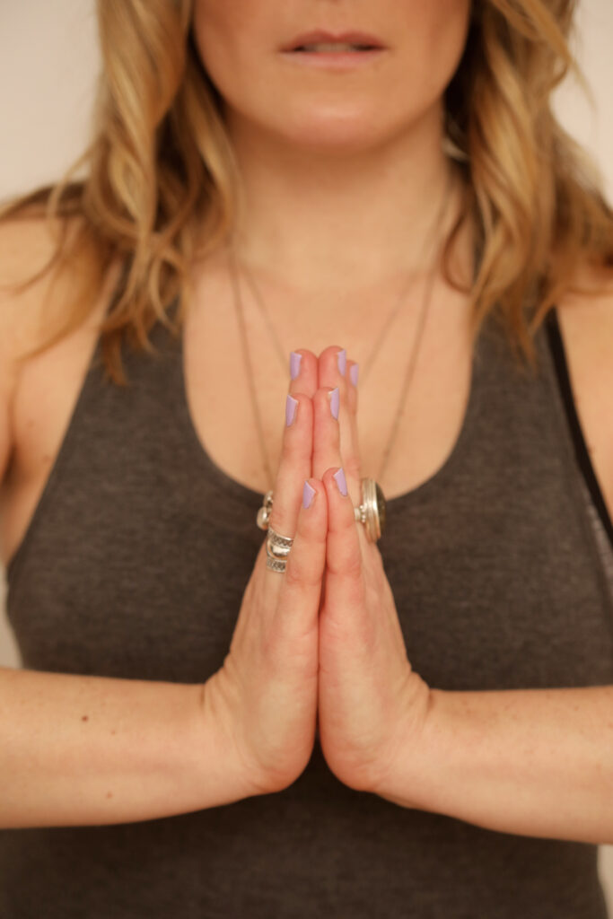 Blonde woman in yoga prayer position.